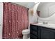 Bathroom with patterned shower curtain, round mirror and dark vanity at 19641 E Emperor Blvd, Queen Creek, AZ 85142