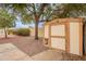 Wooden storage shed in backyard with a door and pegboard at 20449 N 105Th Ave, Peoria, AZ 85382