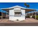 Inviting mobile home exterior with covered carport and landscaping at 205 S Higley Rd # 32, Mesa, AZ 85206