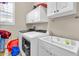 Bright laundry room with washer, dryer, cabinets, and utility sink at 3016 E Maplewood St, Gilbert, AZ 85297
