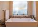 Modern bathroom with freestanding tub, marble tile, and large window at 9440 N 57Th St, Paradise Valley, AZ 85253