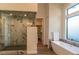 Spa-like bathroom with walk-in shower, soaking tub, and marble finishes at 9440 N 57Th St, Paradise Valley, AZ 85253