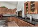 Modern kitchen with granite countertops, wooden cabinetry, and stainless steel appliances at 12448 W Rosewood Ln, Peoria, AZ 85383