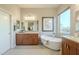 Elegant bathroom with double vanity, soaking tub, and large window at 25803 N 8Th Ave, Phoenix, AZ 85085