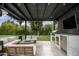 Modern outdoor kitchen and lounge area with built-in grill and TV at 329 E Belmont Ave, Phoenix, AZ 85020