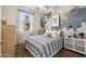 Bright bedroom with striped bedding, world map accent wall, and ample natural light at 40030 W Venture Rd, Maricopa, AZ 85138