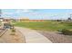 Concrete pathway winds through a grassy park area at 40080 W Venture Rd, Maricopa, AZ 85138