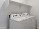 Bright laundry room features Whirlpool washer and dryer, and shelving at 40080 W Venture Rd, Maricopa, AZ 85138