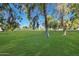 View of a community green space with mature trees and manicured lawn at 604 S Palo Verde Way, Mesa, AZ 85208