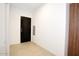 Modern condo entryway with dark wood door and light tile floors at 7120 E Kierland Blvd # 520, Scottsdale, AZ 85254