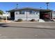 Gray manufactured home with carport, landscaped yard, and palm trees at 8600 E Broadway Rd # 9, Mesa, AZ 85208