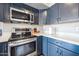 Modern kitchen with stainless steel appliances and dark blue cabinetry at 14850 W Laurel Ln, Surprise, AZ 85379