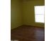 Bright bedroom with wood-look flooring and large window at 30138 W Roosevelt St, Buckeye, AZ 85396