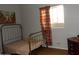 Cozy bedroom with metal bed frame and patterned curtains at 30138 W Roosevelt St, Buckeye, AZ 85396