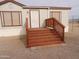 Mobile home entrance with wood stairs and railing at 30138 W Roosevelt St, Buckeye, AZ 85396