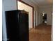 Kitchen and hallway view, featuring a black refrigerator at 30138 W Roosevelt St, Buckeye, AZ 85396