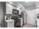 Modern white kitchen with stainless steel appliances and mosaic backsplash at 4413 E Pueblo E Ave, Phoenix, AZ 85040