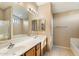 Bathroom with double sinks, large mirror, and separate shower and tub at 45513 W Sky Ln, Maricopa, AZ 85139