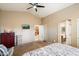 Main bedroom with a dresser, TV, and access to the bathroom at 45513 W Sky Ln, Maricopa, AZ 85139