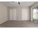 Bedroom with carpet flooring, ceiling fan and sliding glass door at 8924 W Mackenzie Dr, Phoenix, AZ 85037