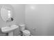 Clean bathroom with pedestal sink, toilet, and oval mirror at 9814 E Palladium Dr, Mesa, AZ 85212