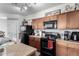 Modern kitchen with dark wood cabinets, black appliances, and an island at 1265 S Aaron -- # 359, Mesa, AZ 85209