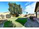 Landscaped backyard with grassy area and patio at 14866 W Windrose Dr, Surprise, AZ 85379