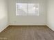 Well-lit bedroom featuring carpeted floors and a window with blinds at 2424 E Villa Maria Dr, Phoenix, AZ 85032