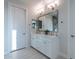 Double vanity bathroom with white cabinets and a large mirror at 31740 N 116Th Dr, Peoria, AZ 85383