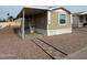 Tan mobile home with carport and landscaped yard at 9431 E Coralbell Ave # 32, Mesa, AZ 85208