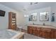 Elegant bathroom with a double vanity, walk-in shower, and soaking tub at 13802 N 64Th Pl, Scottsdale, AZ 85254