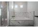 Modern bathroom featuring a soaking tub and marble tile at 22538 W Pecan Rd, Buckeye, AZ 85326