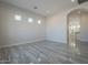 Bedroom with arched entry to ensuite bathroom and gray tile flooring at 22538 W Pecan Rd, Buckeye, AZ 85326