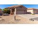 Tan house with two-car garage and desert landscaping at 11553 W Sonoran Ct, Surprise, AZ 85378