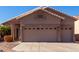 Two-car garage and front entry of tan house at 11553 W Sonoran Ct, Surprise, AZ 85378