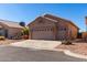 Tan house with two-car garage and desert landscaping at 11553 W Sonoran Ct, Surprise, AZ 85378