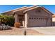 Tan house with two-car garage and desert landscaping at 11553 W Sonoran Ct, Surprise, AZ 85378