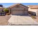 Two-car garage and front yard with desert landscaping at 11553 W Sonoran Ct, Surprise, AZ 85378