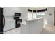 Bright kitchen with island, black appliances, and ample cabinet space at 11553 W Sonoran Ct, Surprise, AZ 85378