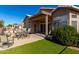 Covered patio with seating area, and grassy backyard at 11553 W Sonoran Ct, Surprise, AZ 85378