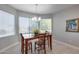 Bright dining room with wood table and chairs, large windows, and a chandelier at 15303 W Paradiso Ct, Surprise, AZ 85374