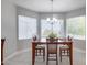 Bright dining room with wood table and chairs, large windows, and a chandelier at 15303 W Paradiso Ct, Surprise, AZ 85374