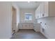 Bright laundry room with white cabinets and tile floor at 21875 E Misty Ln, Queen Creek, AZ 85142