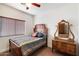 Well-lit bedroom with antique wooden bed and dresser at 21995 N 76Th Ln, Peoria, AZ 85383