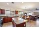 Eat-in kitchen with granite island, wood cabinets, and views into adjacent living area at 21995 N 76Th Ln, Peoria, AZ 85383