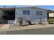 White single-wide manufactured home with covered porch and landscaping at 4065 E University Dr # 373, Mesa, AZ 85205