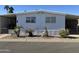 Mobile home with carport, landscaping, and paved driveway at 4065 E University Dr # 373, Mesa, AZ 85205
