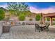 Outdoor kitchen and dining area with fireplace and mountain views at 10030 N 23Rd St, Phoenix, AZ 85028