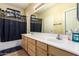 Bathroom with double vanity, tub, and dark shower curtain at 1306 S Normandy --, Mesa, AZ 85209