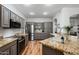 Open concept kitchen with granite countertops and gray cabinets at 17221 N Thornberry Dr, Surprise, AZ 85374